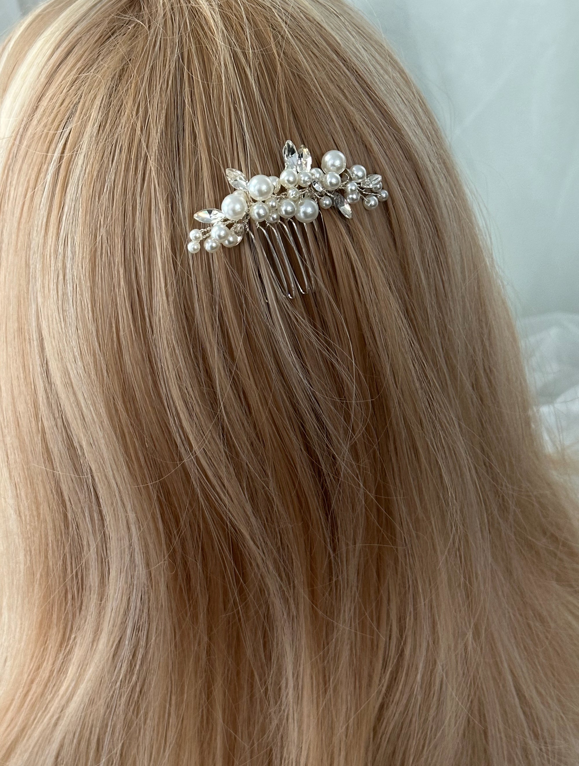 Pearl and crystal hair comb in blonde hair against a neutral background