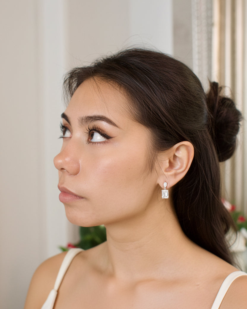Close-up of a woman wearing diamond earrings with a blurred background