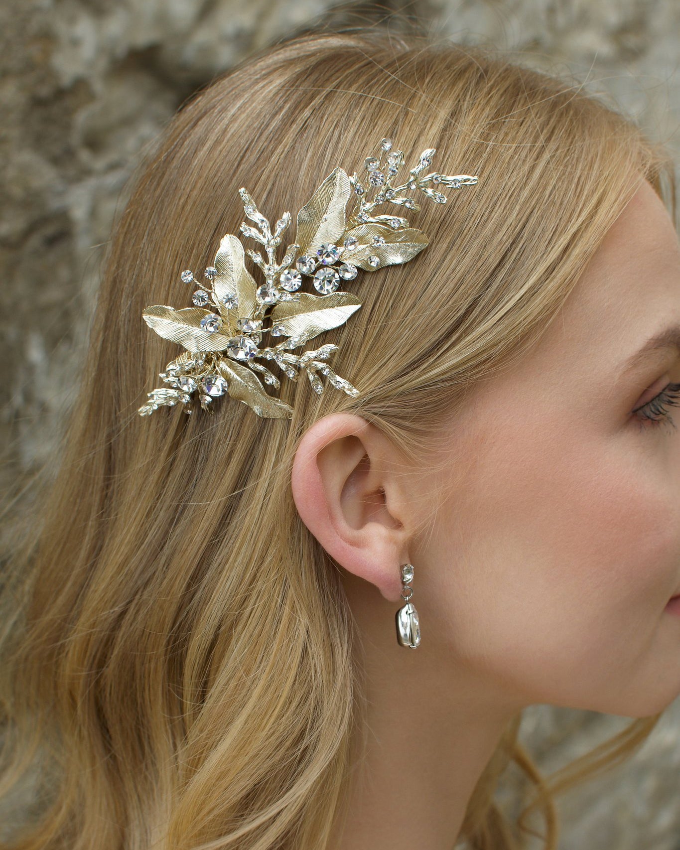 Blonde model wearing pale gold bridal side comb with pear shape gold earring