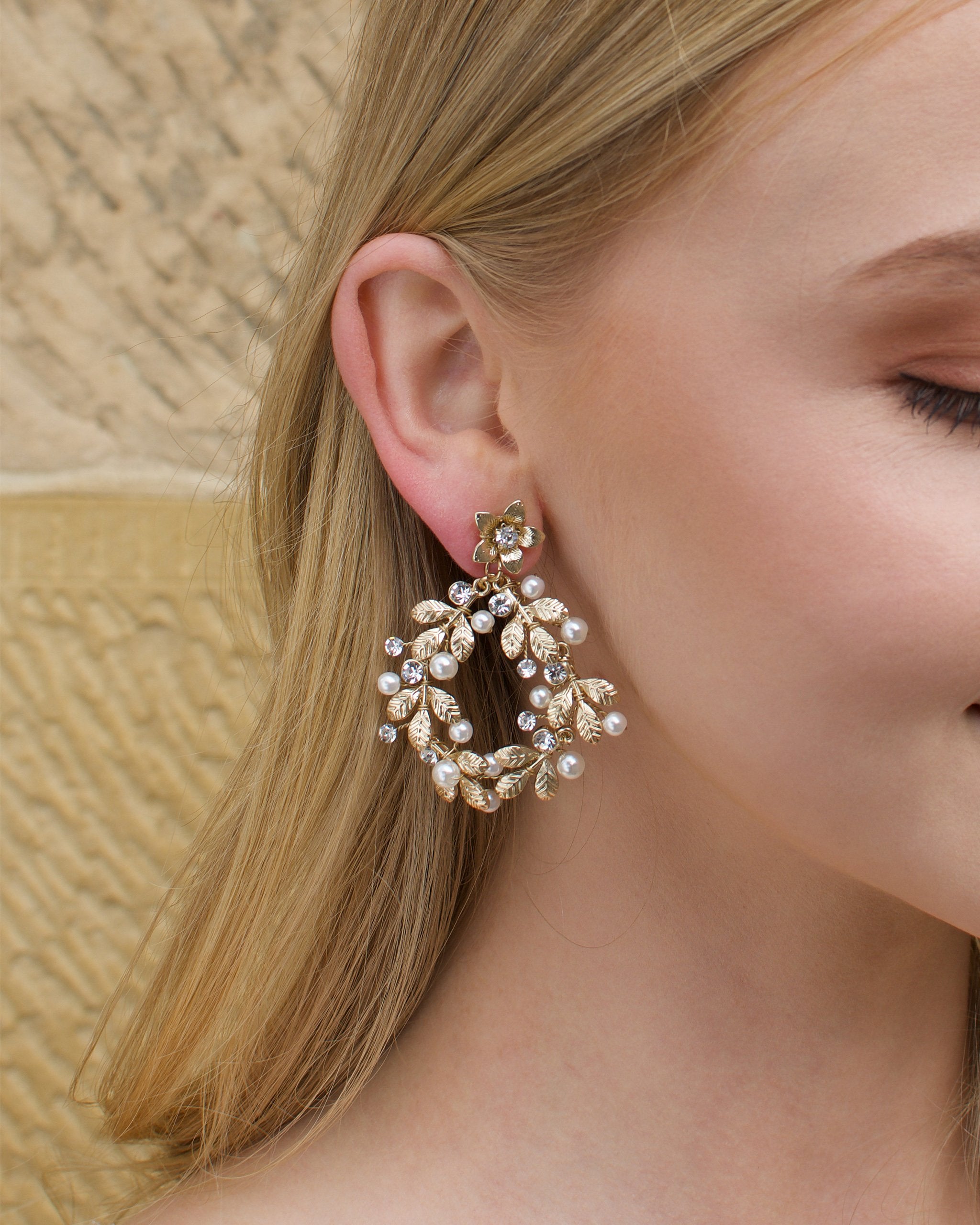 Large hoop shape gold earring worn by a blonde model
