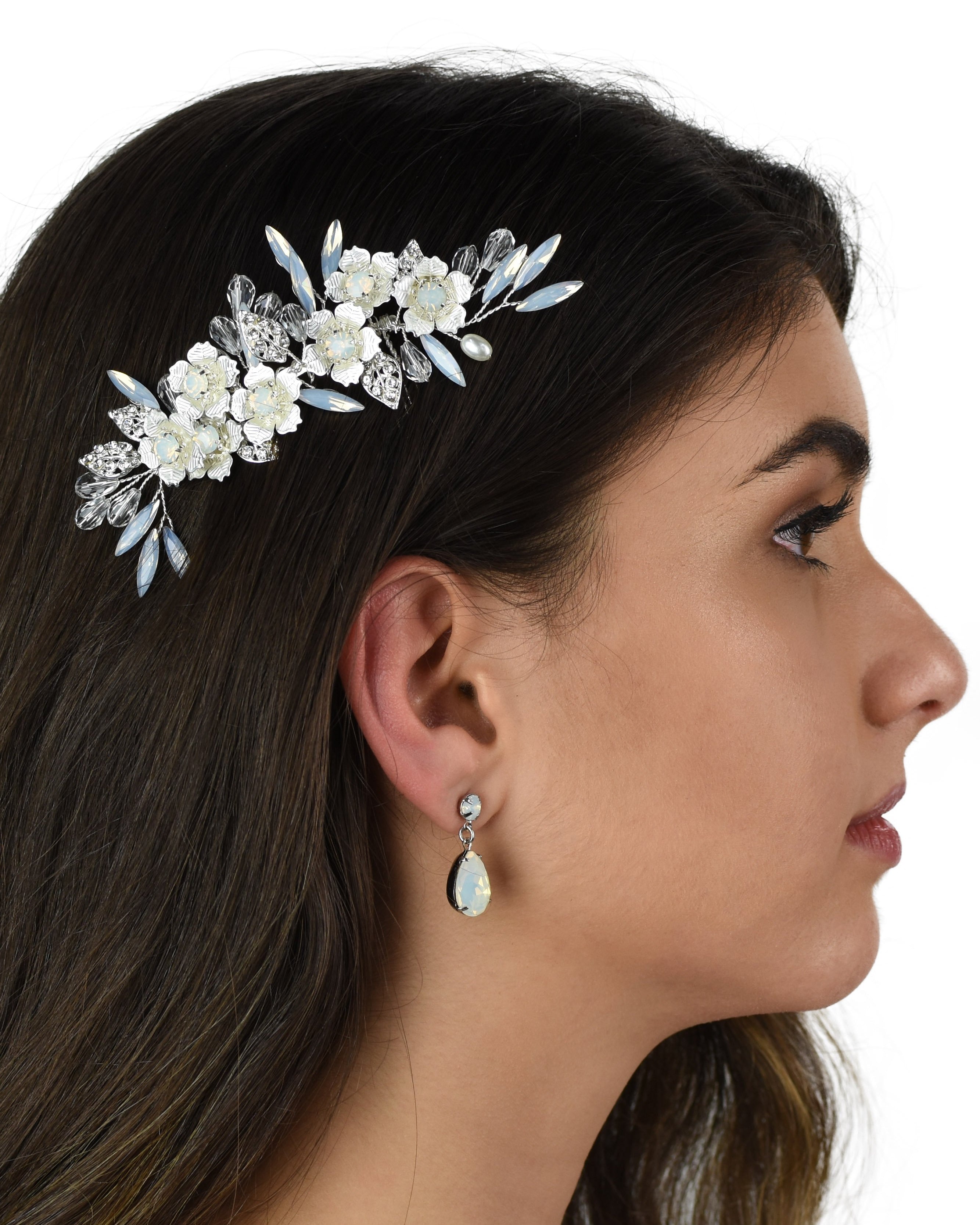 Dark Haired model wears a small silver comb with white opal stones against a white background
