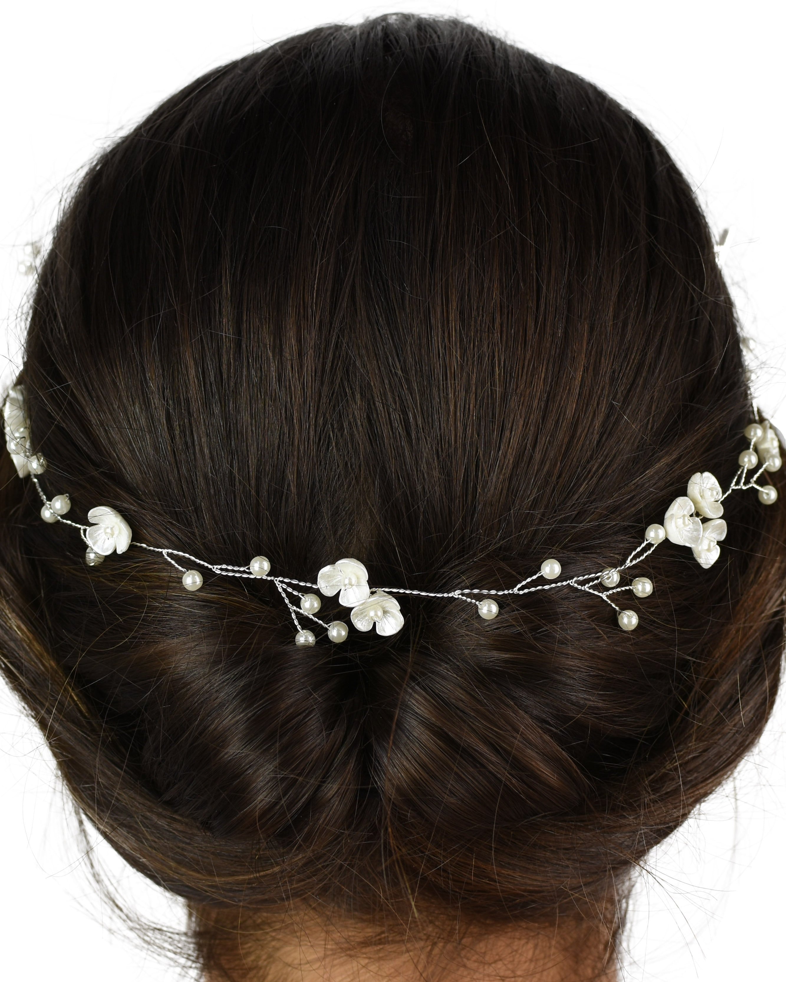 The back of a dark model's head wearing a silver vine with pearls
