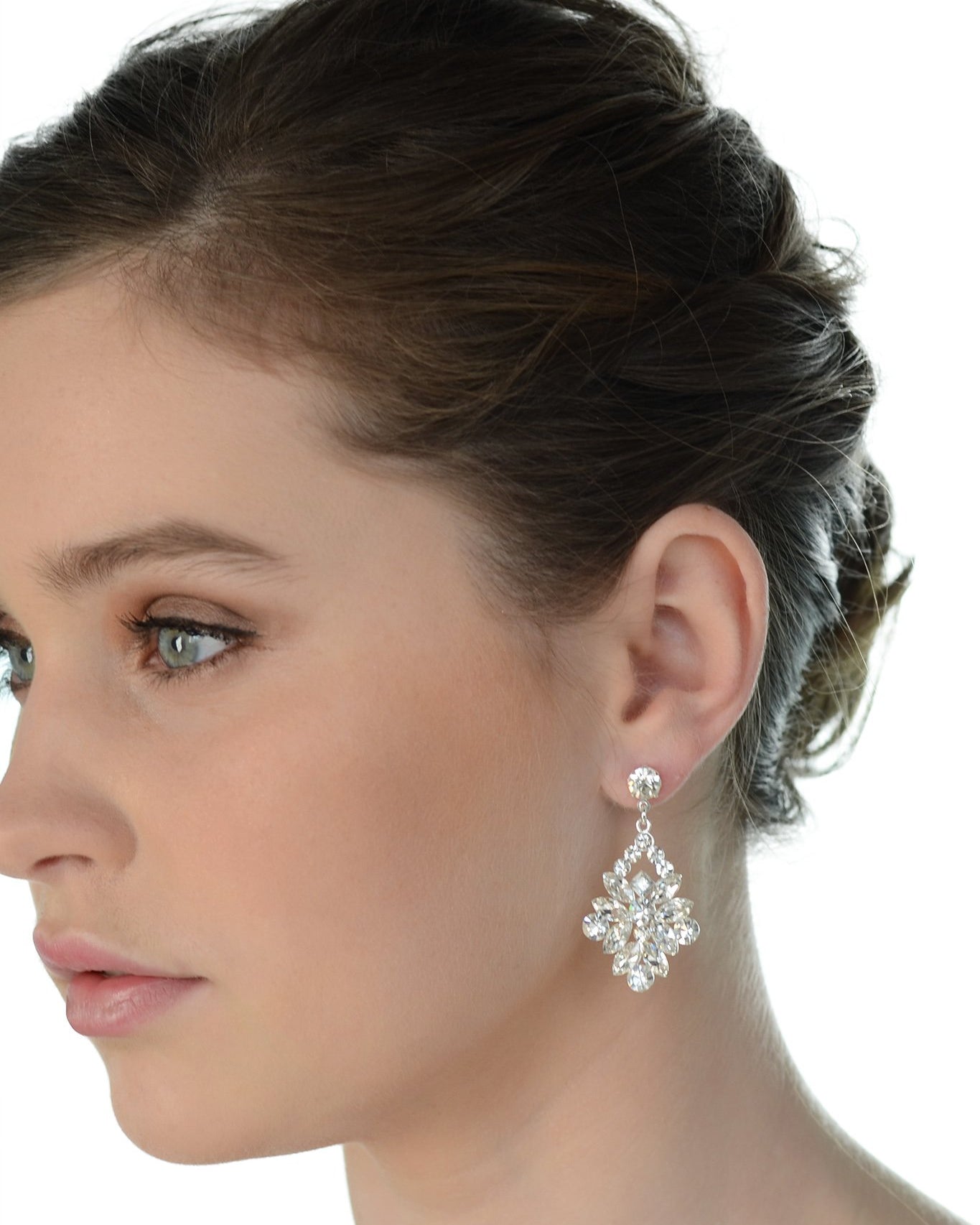 A dark haired model wears a wide drop earring with a white background