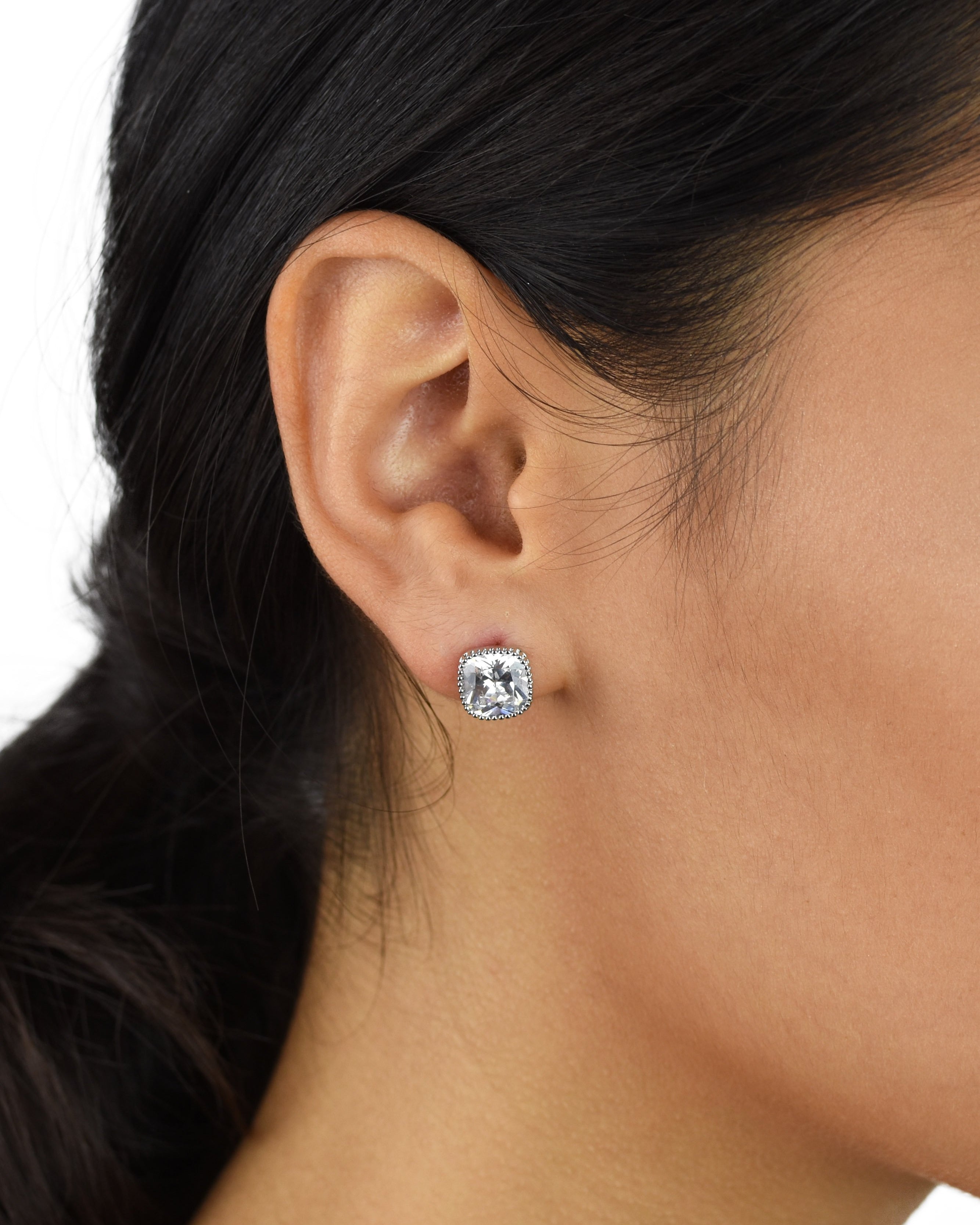 Square shape crystal stud earring with rounded edges worn in the ear of a model