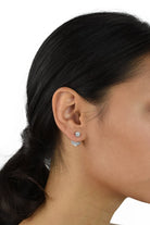 Dark hair model with pony tail hairstyle wears a double crystal ball earring
