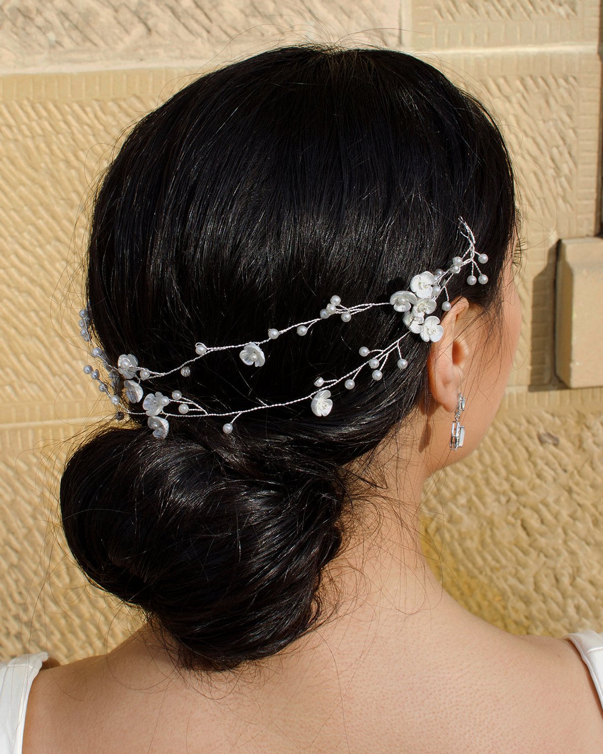 Twin row vine in silver worn by a dark hair model with a sandstone wall backdrop