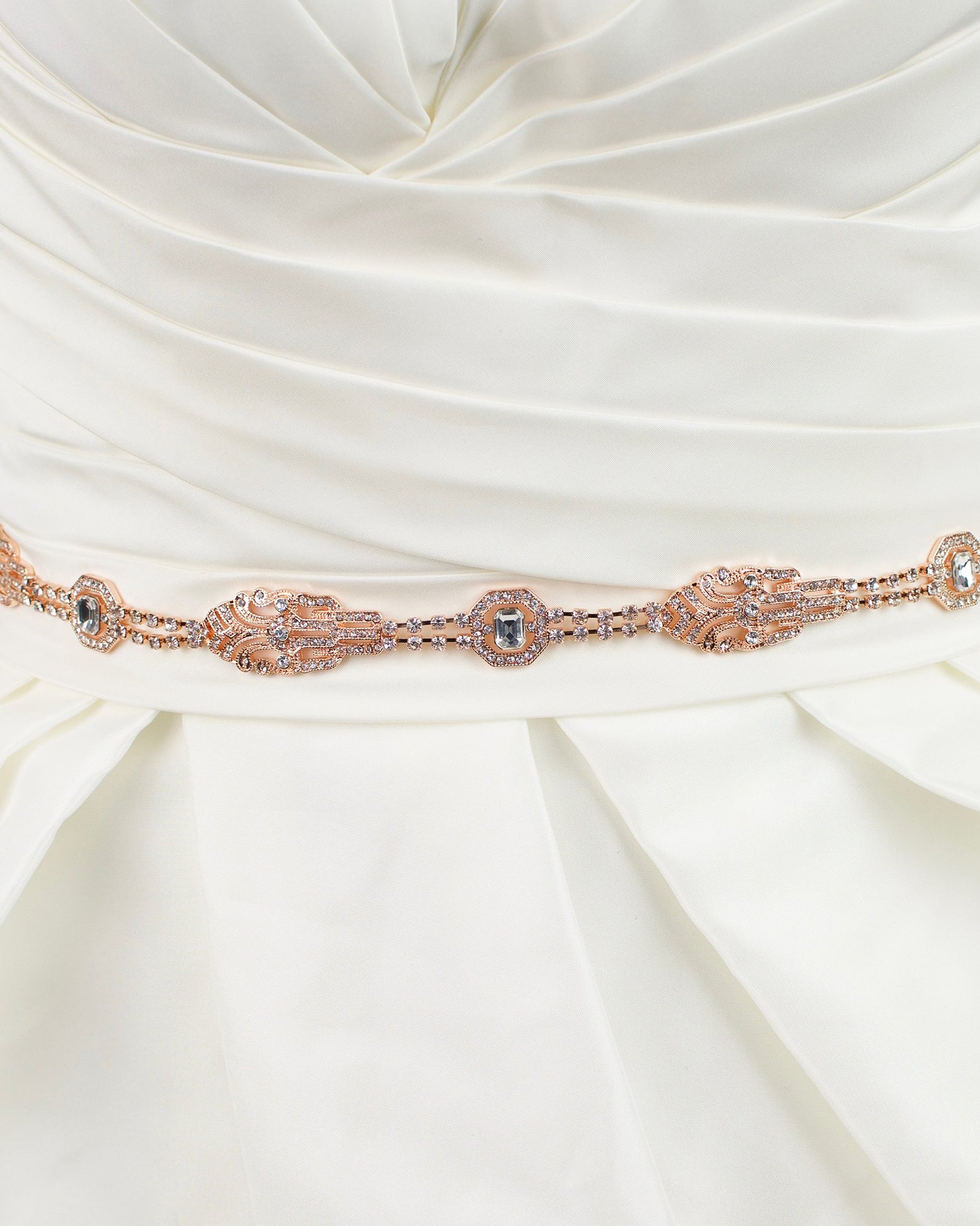 A rose gold narrow bridal belt worn on an ivory bridal gown