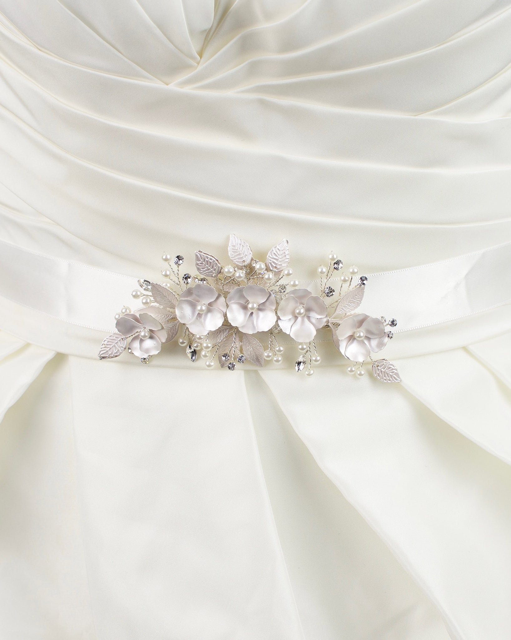 Soft pale pink metal flowers belt on ivory satin ribbon worn on a bridal gown