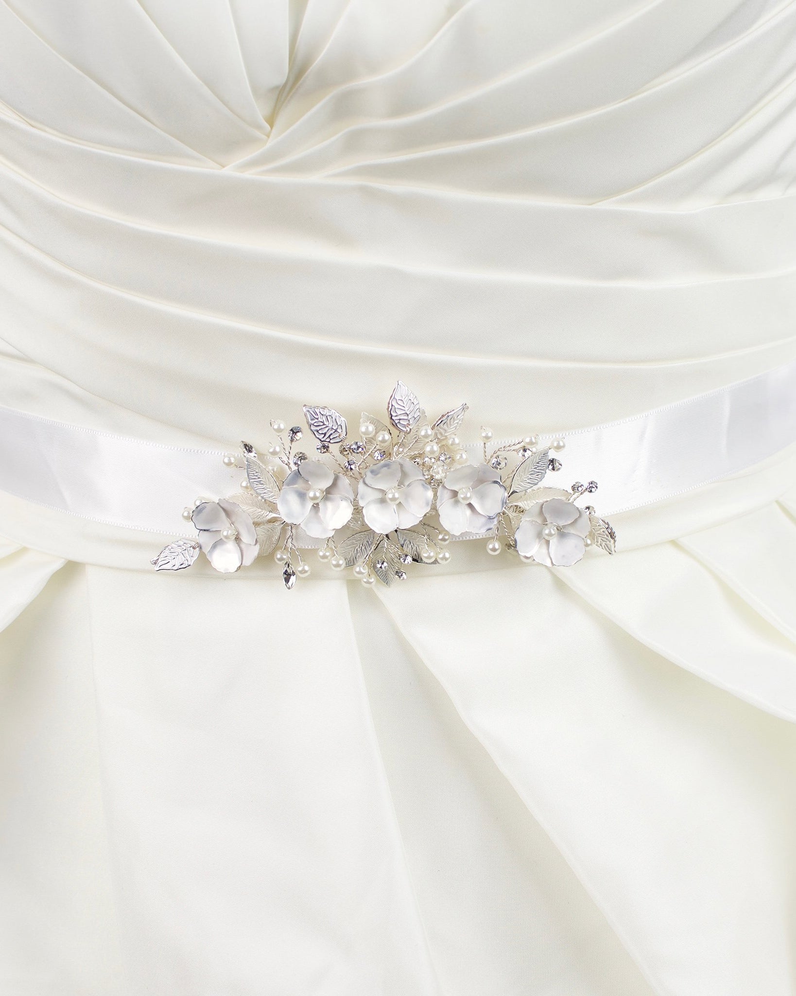 Soft white hand painted flowers on a bridal belt worn on an ivory satin gown
