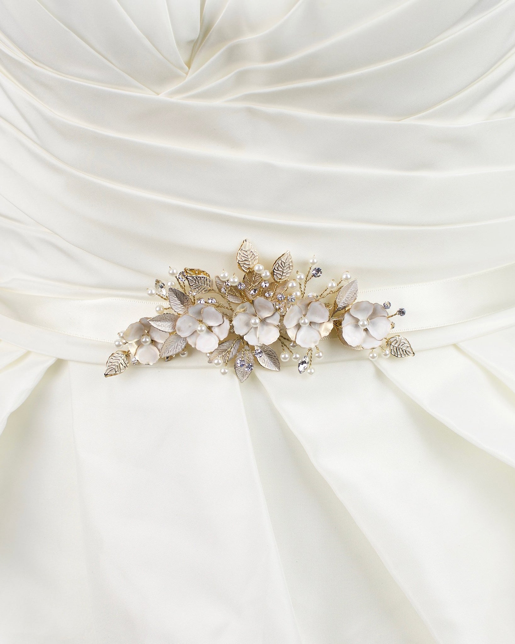 Soft pale gold flowers on an ivory satin bridal belt worn on an ivory bridal gown