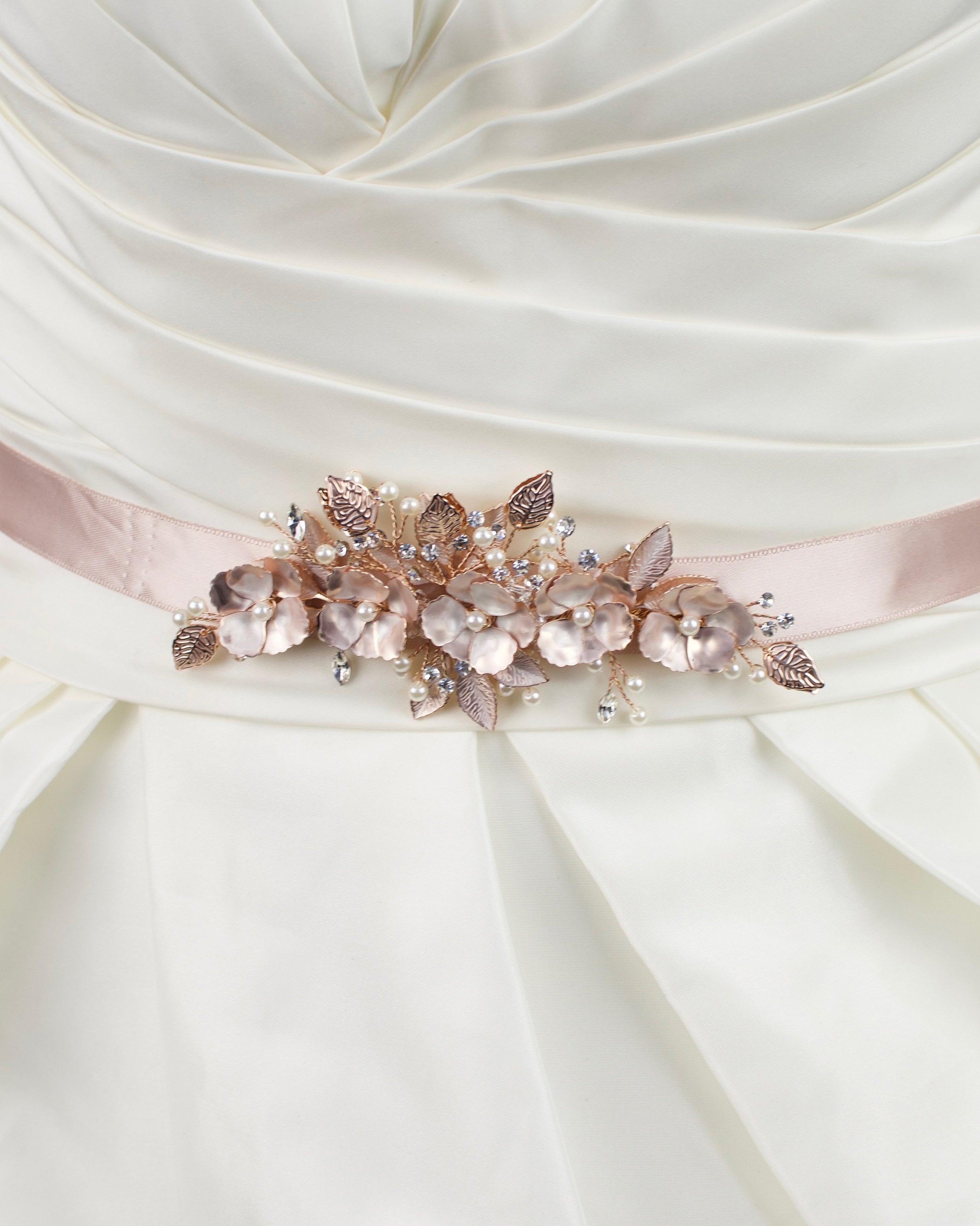 Soft Rose Gold Flowers on a dusty pink satin ribbon bridal belt worn on an ivory bridal gown