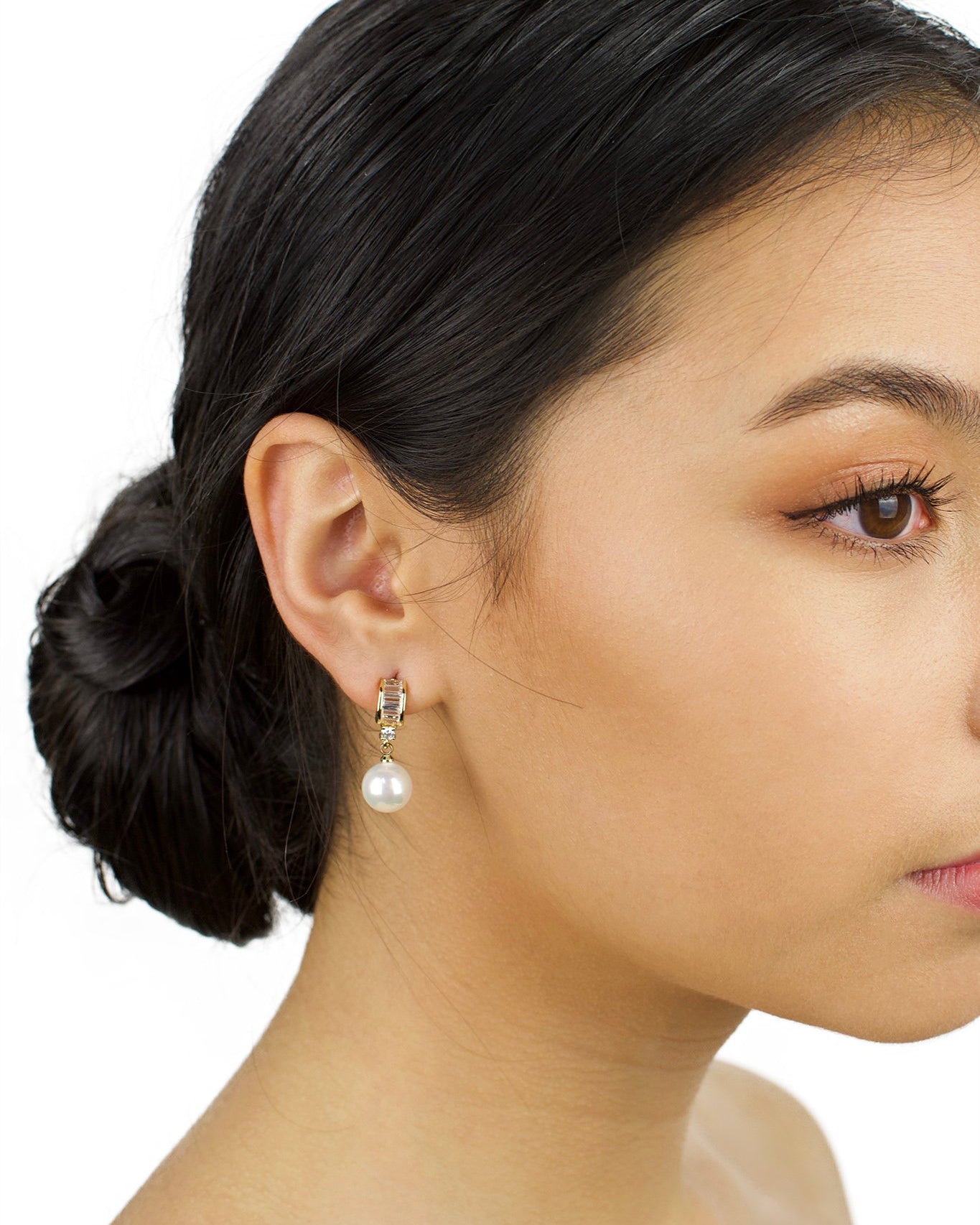 Small Gold and pearl drop earring worn by a dark haired bridal model