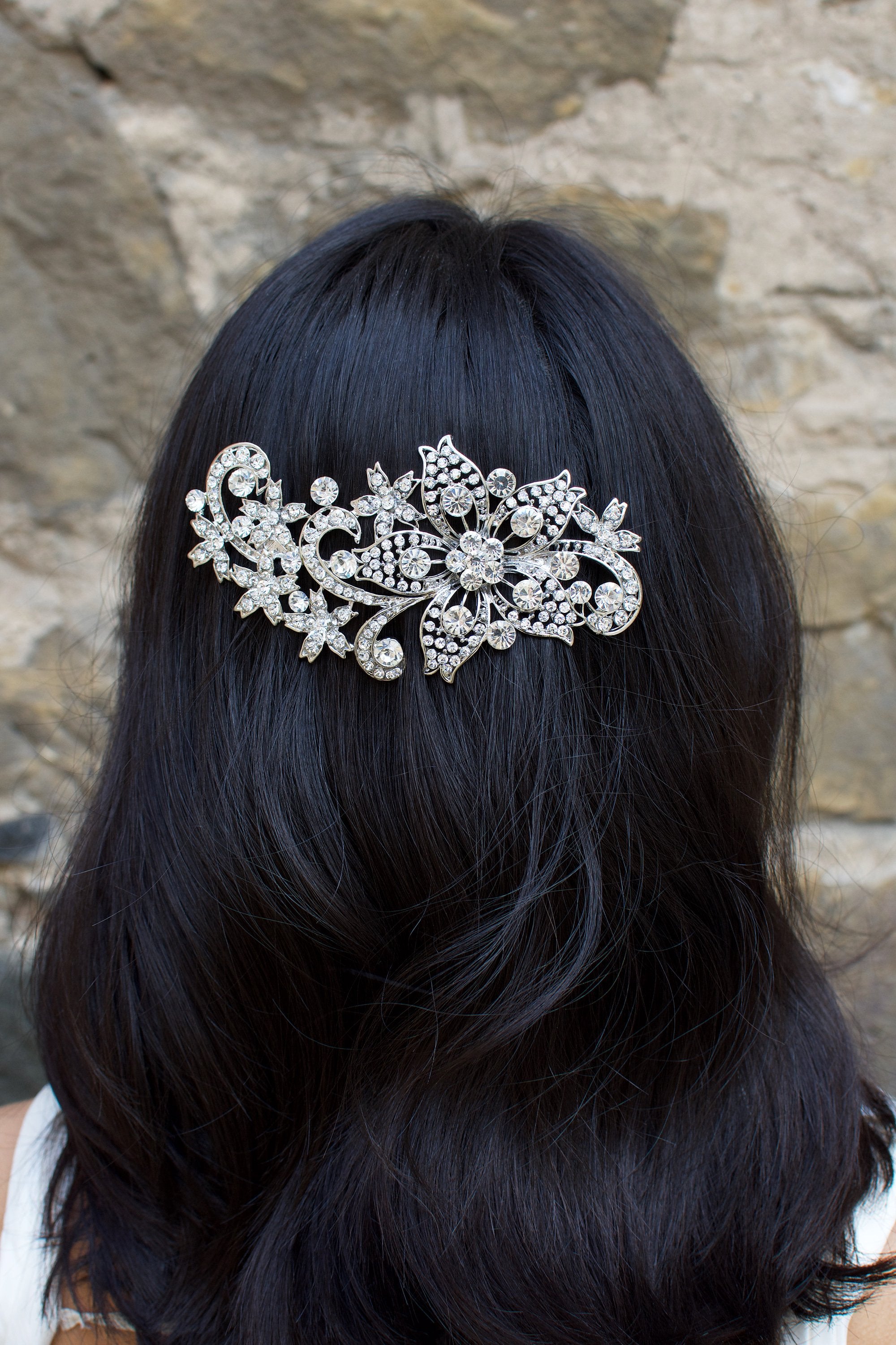 Dark hair model with her hair down wears a dark silver comb.