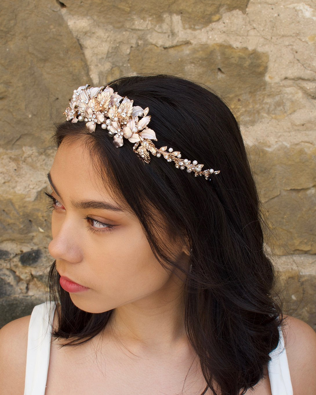 Black haired model wears a pale rose gold and pearl low bridal headband