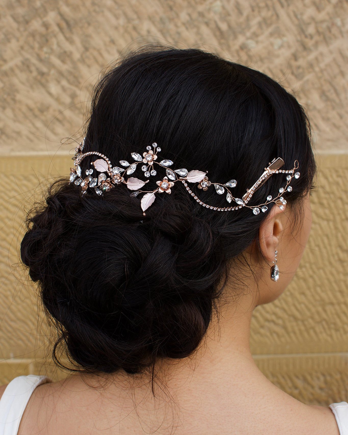 Rose Gold Bridal Vine with leaves and Flowers in the hair of a model with a stone wall backdrop
