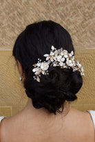 Model Bride wears a Pale Gold Bridal Vine on her dark hair with a wall as background