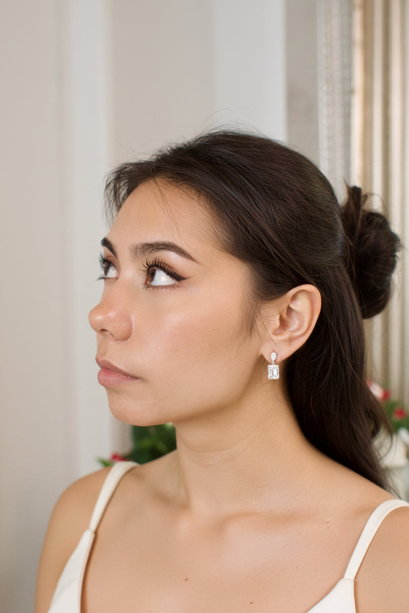 Close-up of a woman wearing diamond earrings with a blurred background