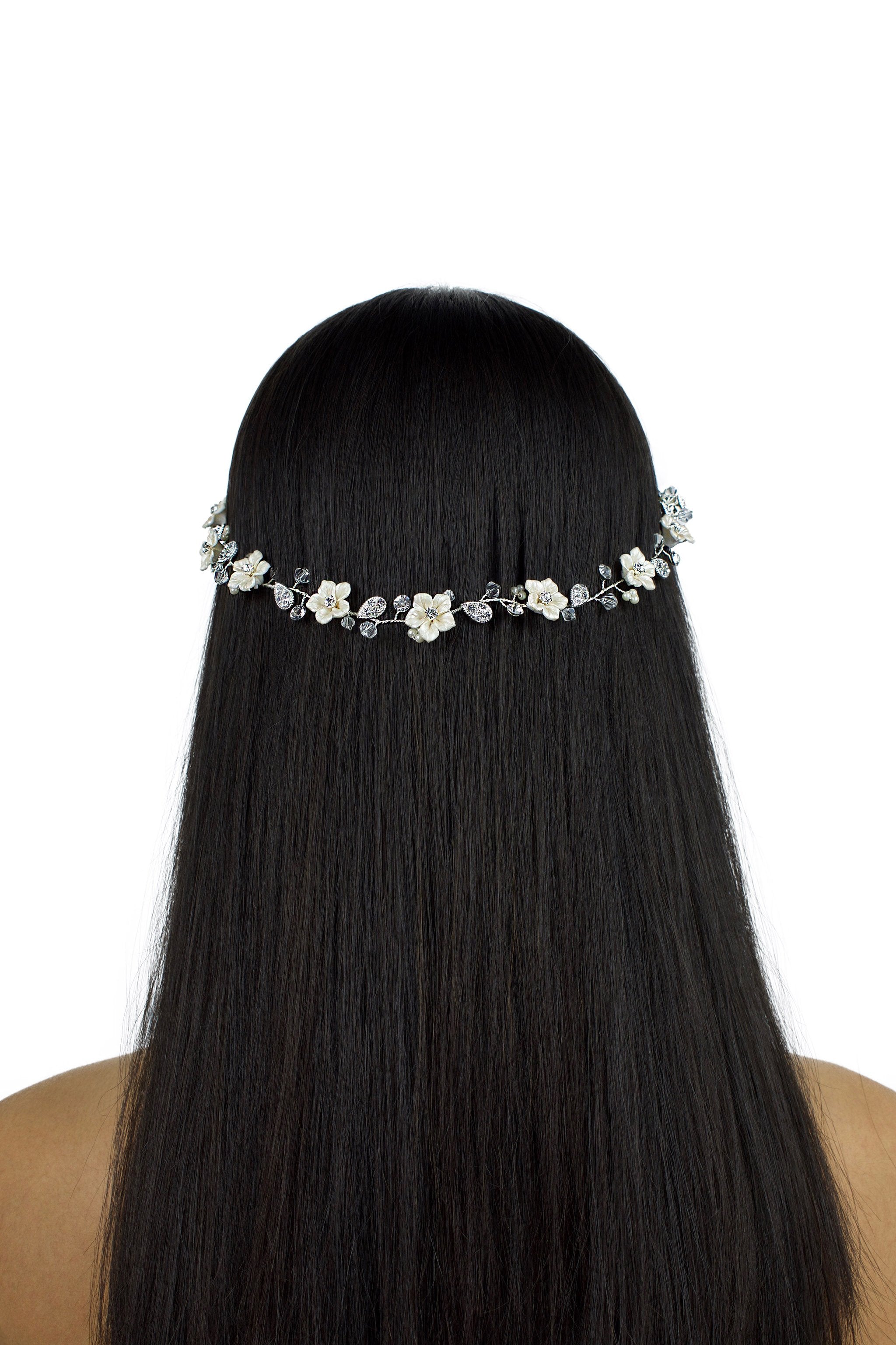 Model with long black hair wears a single strand flowers bridal vine with a white background