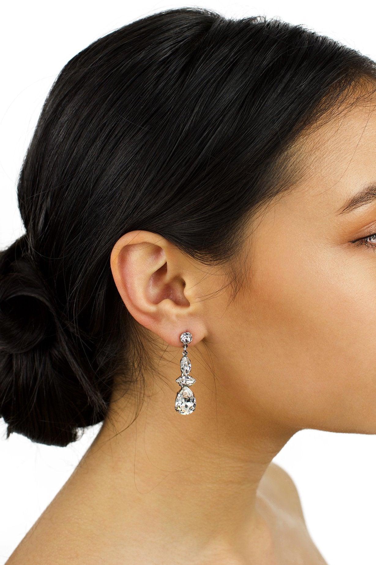 Dark hair model wearing a short Swarovski Crystal drop earring with a white background