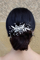 Silver leaf comb at the back of a brides head on dark hair with a stone wall backdrop