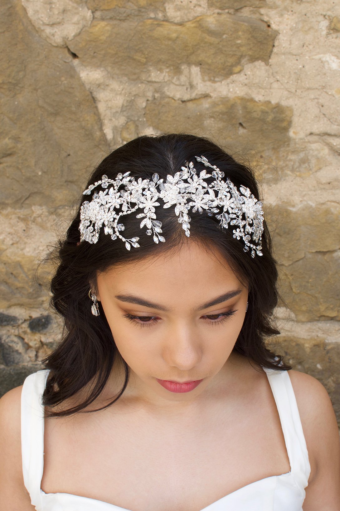 Silver and crystal headband worn by a bridal model at the front of her head