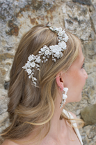 Blonde haired girl wears ceramic white flower and leaf vine.