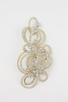 A champagne gold bridal comb with many tiny crystals sits on a pure white background